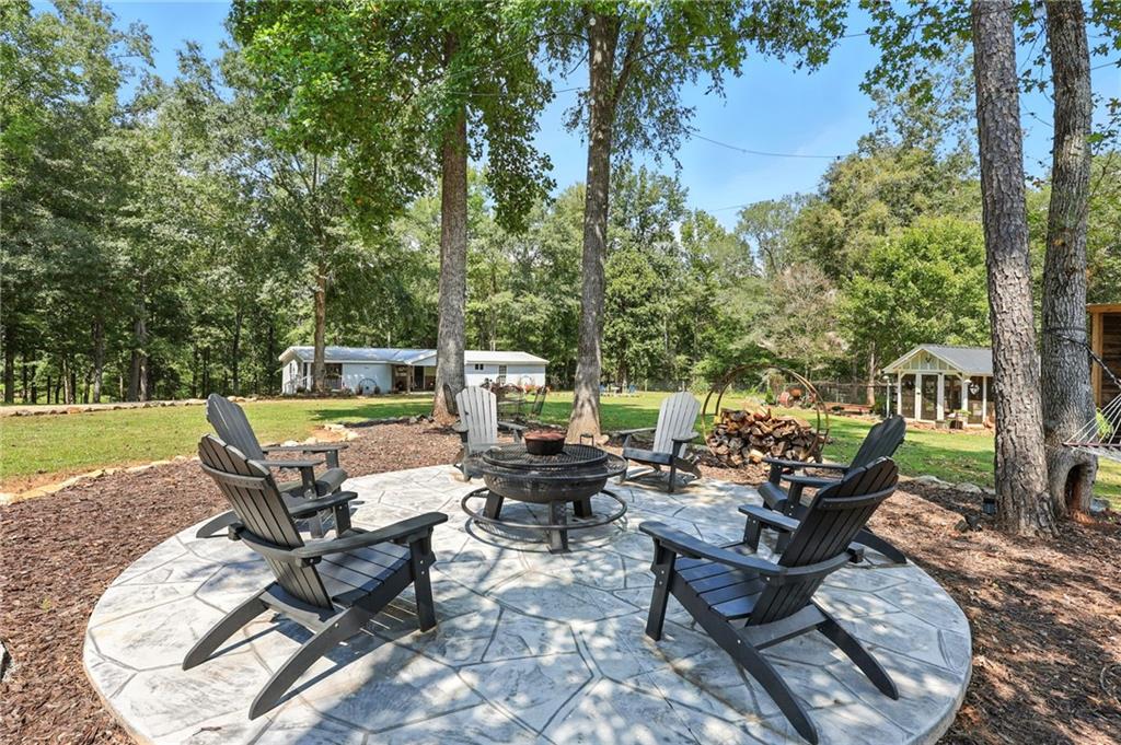 731 Borders Road Commerce, GA 30530 - Photo 44 of 75 a view of a patio with table and chairs potted plants and a large tree