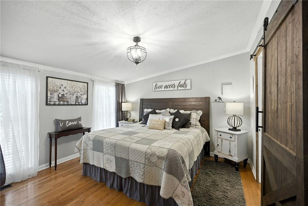 731 Borders Road Commerce, GA 30530 - Photo 67 of 75 a bedroom with a bed and a chandelier