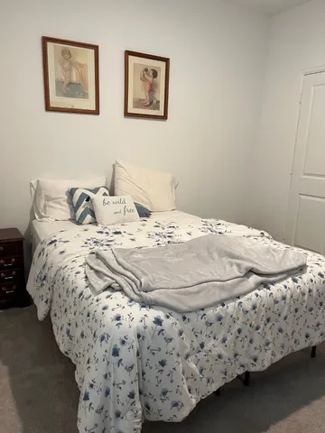 a bed sitting in a bedroom next to a bathroom