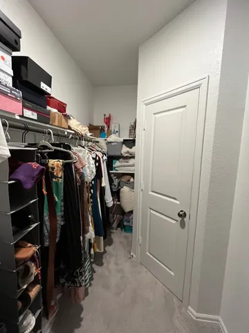 a view of walk in closet with clothes and shoes