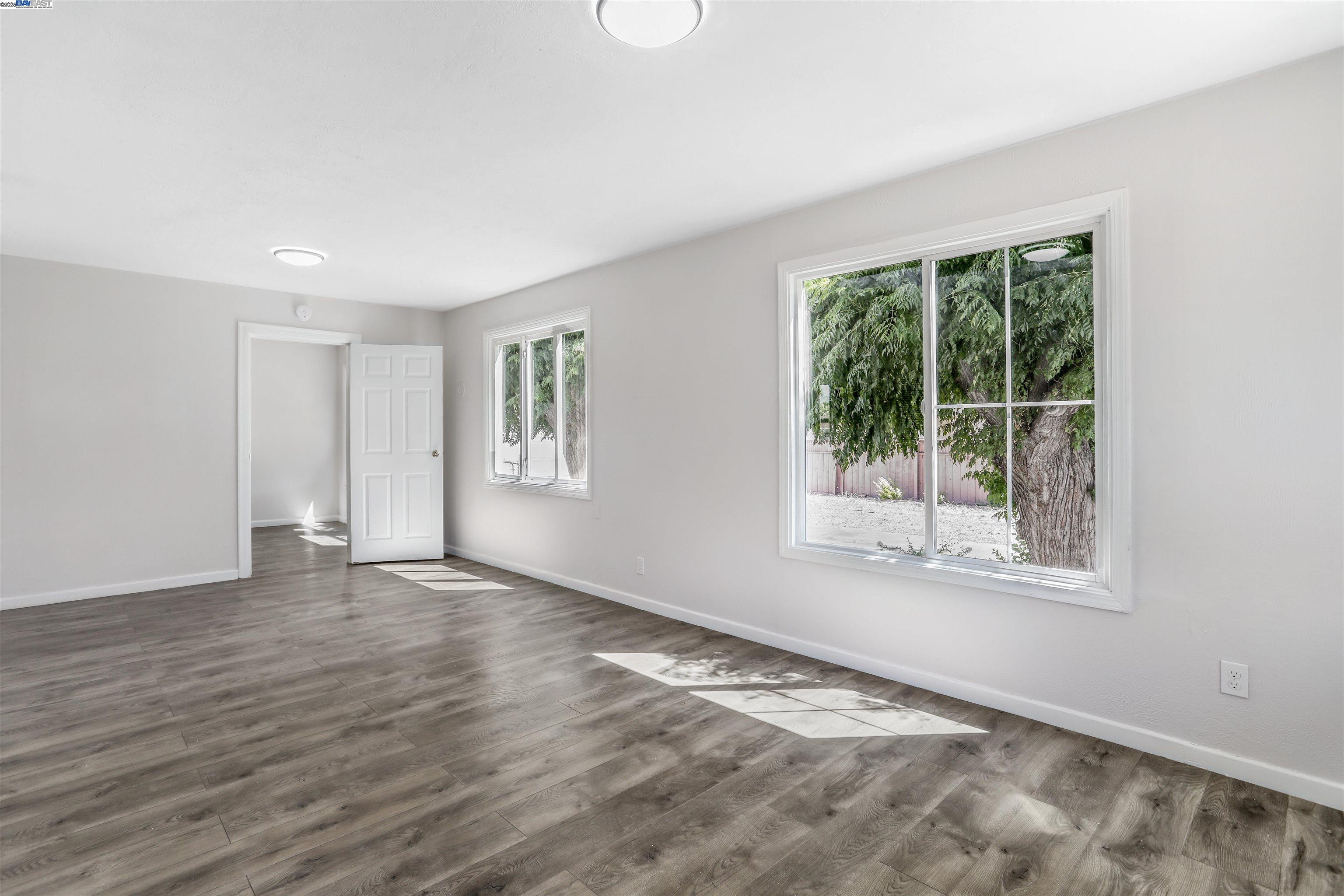1925 Alpha Way Antioch, CA 94509 - Photo 6 of 26 a view of an empty room with wooden floor and a window