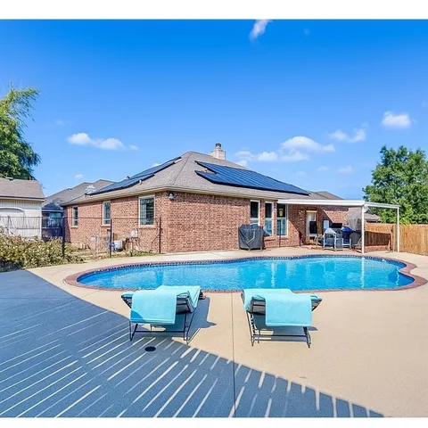 a view of house with swimming pool outdoor seating