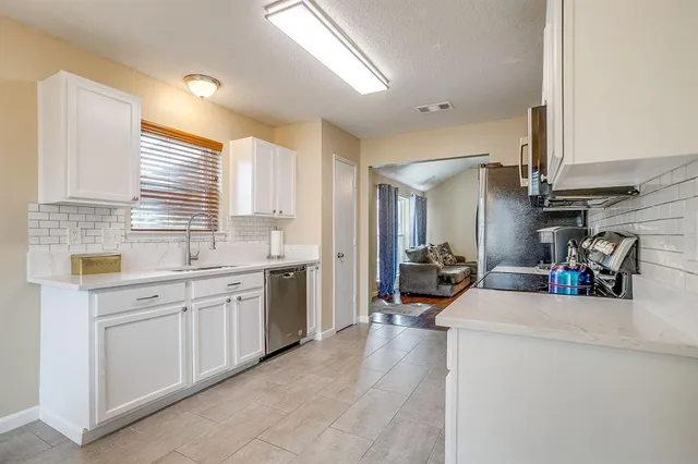 a kitchen with sink cabinets and appliances
