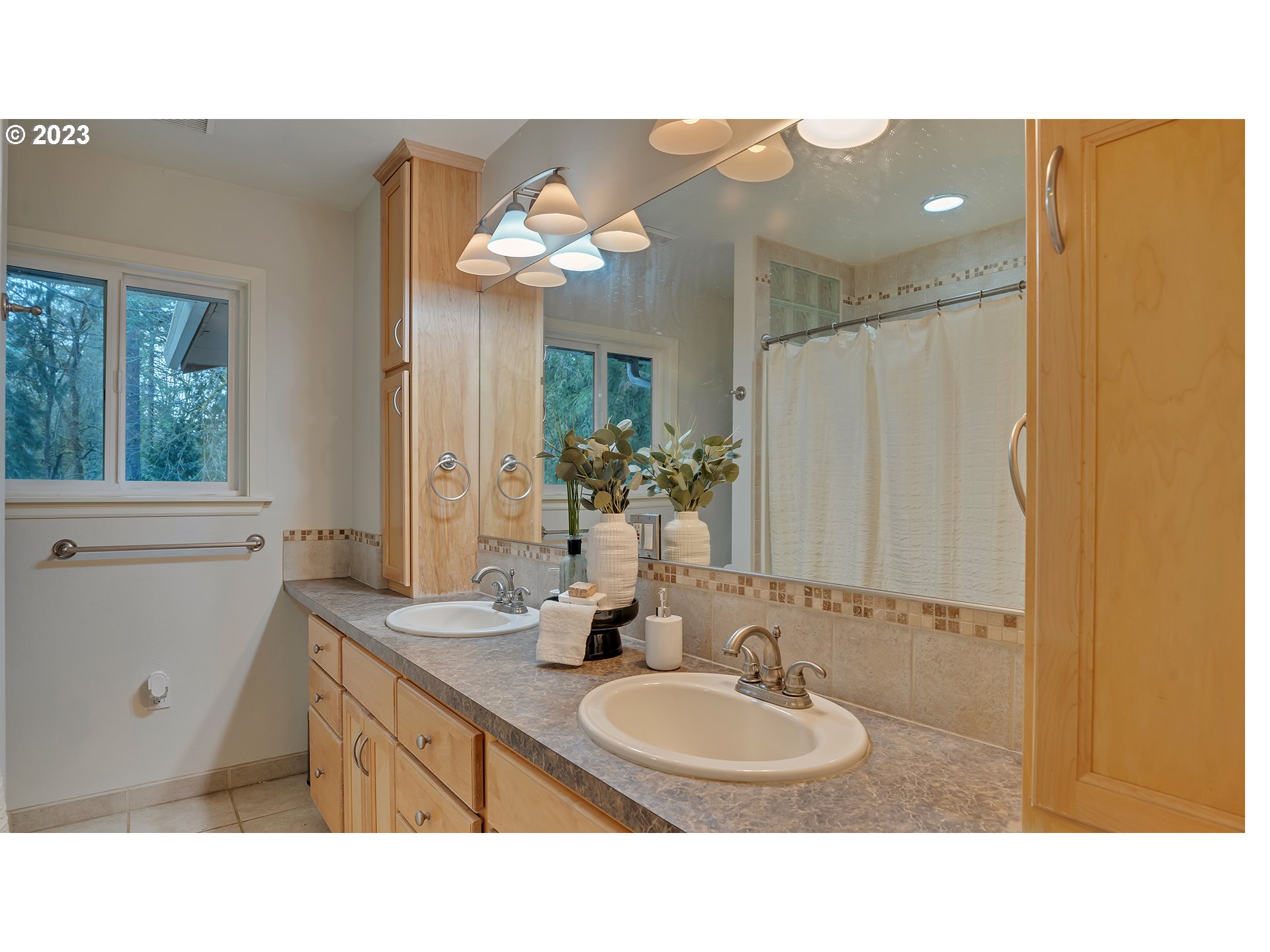 660 Southwest Maplecrest Drive Portland, OR 97219 - Photo 20 of 32 a bathroom with a sink two mirror and a window