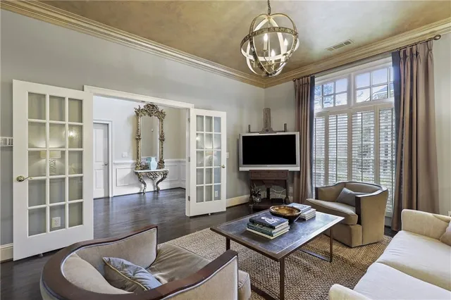 a living room with furniture a flat screen tv and a large window