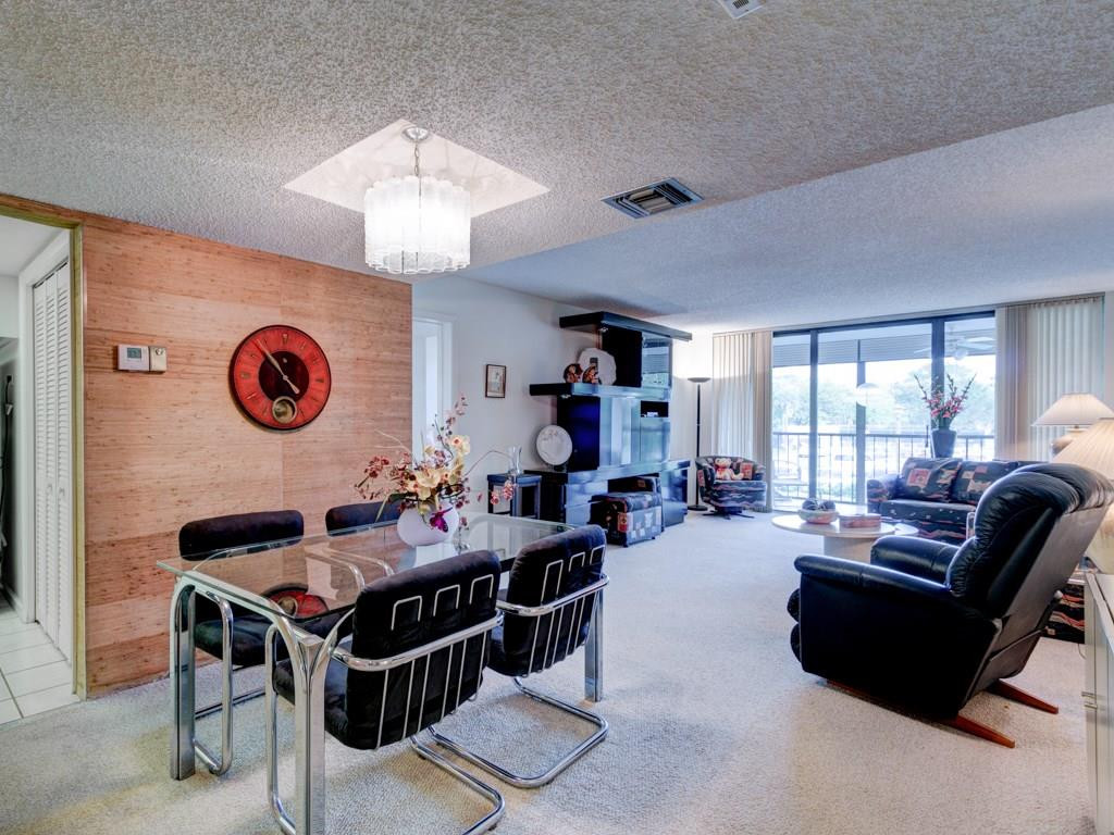 16400 Golf Club Road, Unit 204 Weston, FL 33326 - Photo 10 of 31 a living room with furniture a table and a chandelier