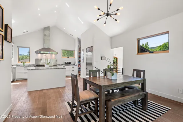 a kitchen with a table chairs refrigerator and cabinets