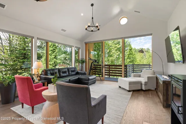 a living room with furniture and a floor to ceiling window