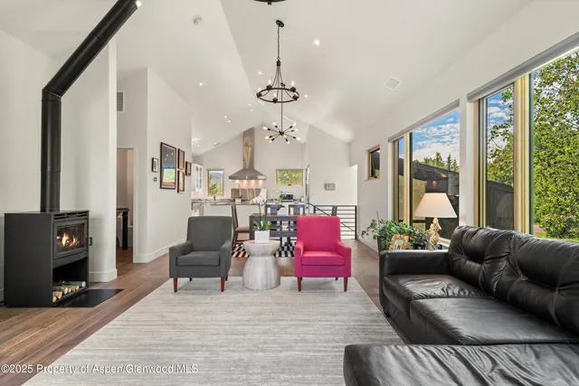 a living room with furniture a flat screen tv and a floor to ceiling window