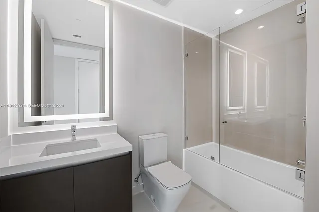 a bathroom with a sink toilet vanity and shower