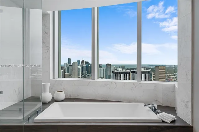 a bathroom with a bathtub and next to a window