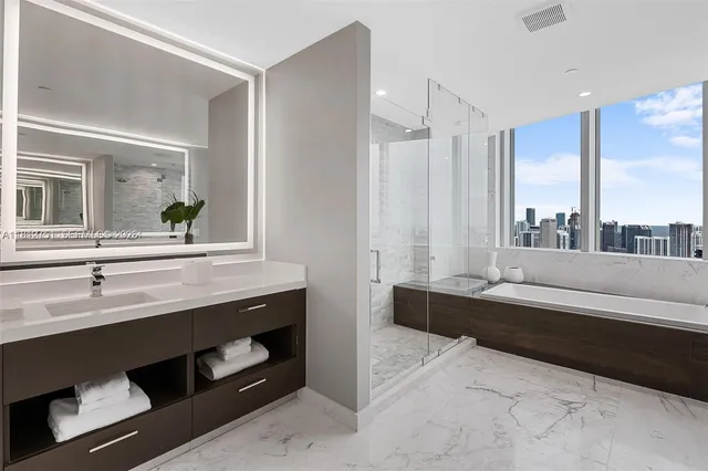 a bathroom with a tub a sink and a large mirror