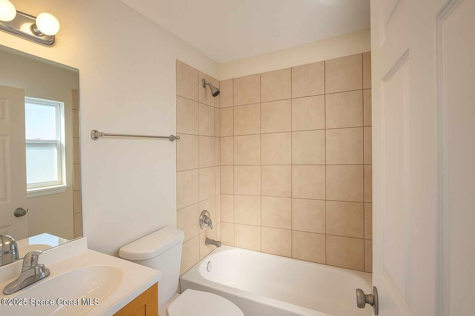 819 Angela Avenue, Unit B Rockledge, FL 32955 - Photo 9 of 11 a bathroom with a sink a toilet and bathtub