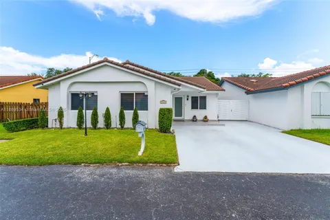 a view of a house with a patio and a yard