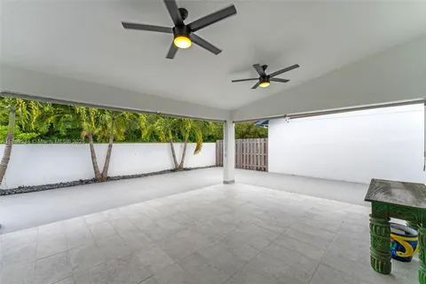 an empty room with a ceiling fan and window