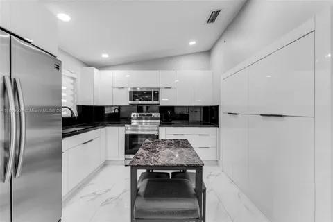 a kitchen with stainless steel appliances a refrigerator stove microwave and sink