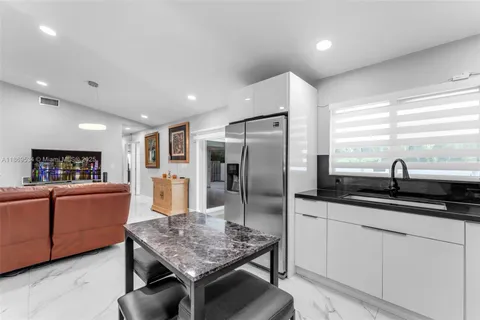 a kitchen with stainless steel appliances granite countertop a sink refrigerator and cabinets