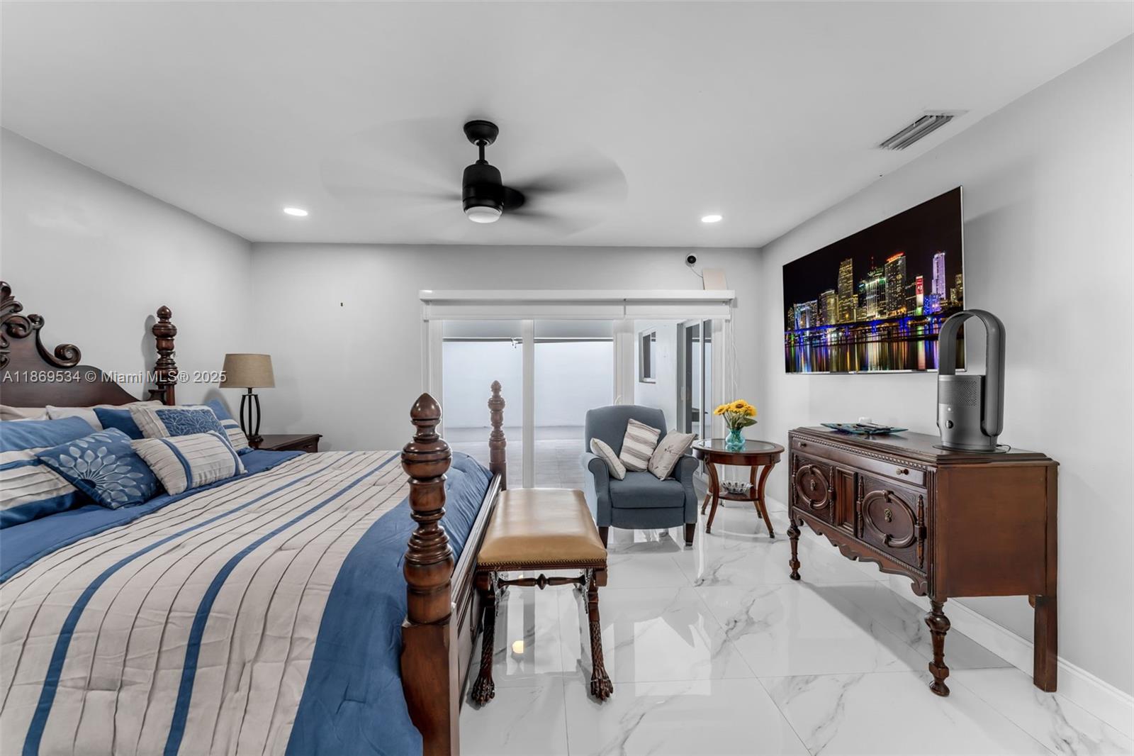 11186 Southwest 75th Terrace Miami, FL 33173 - Photo 10 of 26 a bedroom with a bed a couch and a bookshelf with wooden floor