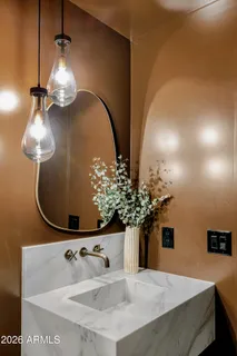 a kitchen with stainless steel appliances white cabinets a sink a stove a chimney a potted plant and cabinets