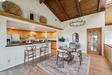 a kitchen with stainless steel appliances granite countertop a table chairs and a refrigerator