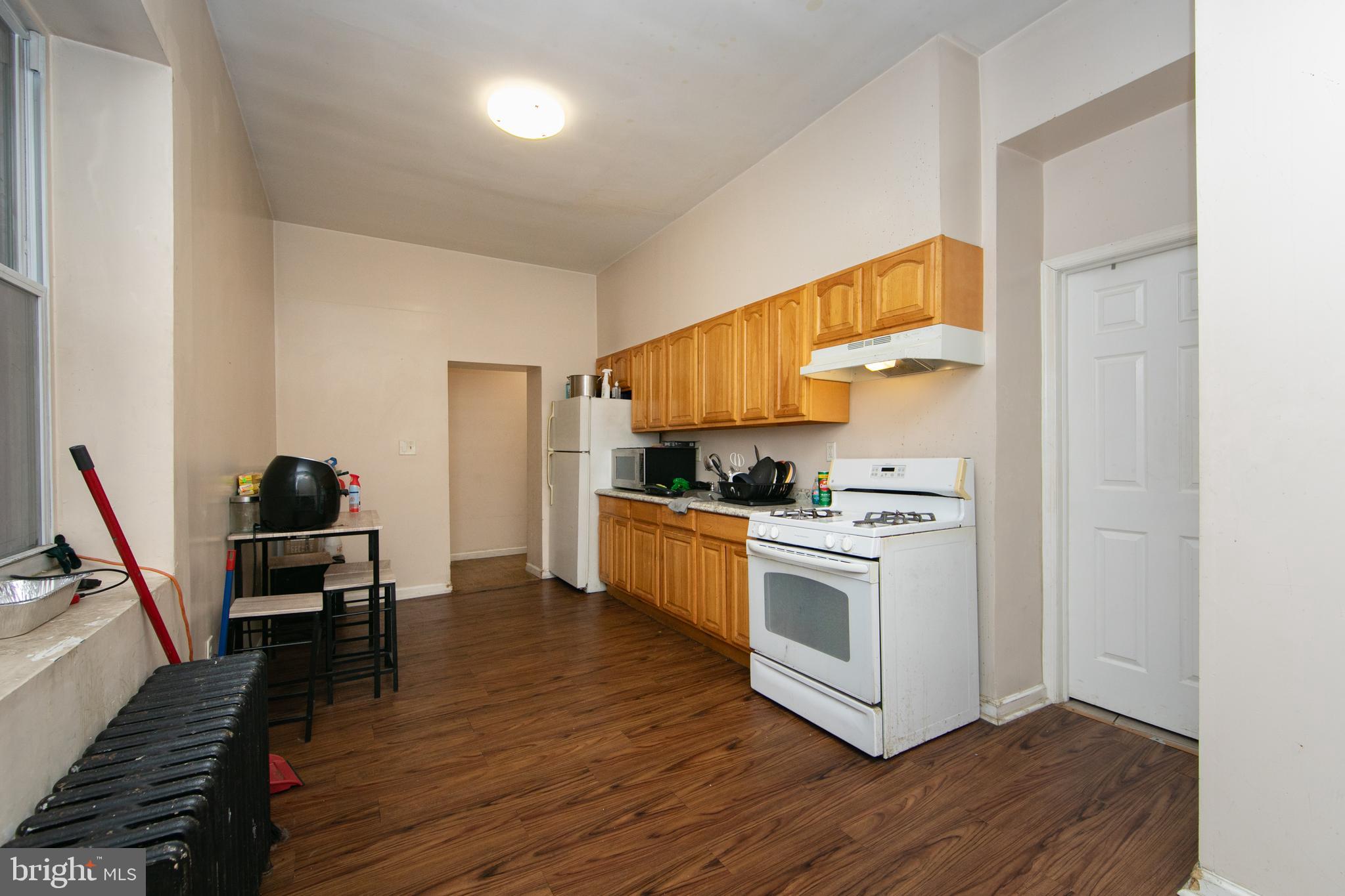 1574 Mt Ephraim Avenue Camden, NJ 08104 - Photo 28 of 54 a kitchen with white cabinets and wooden floor