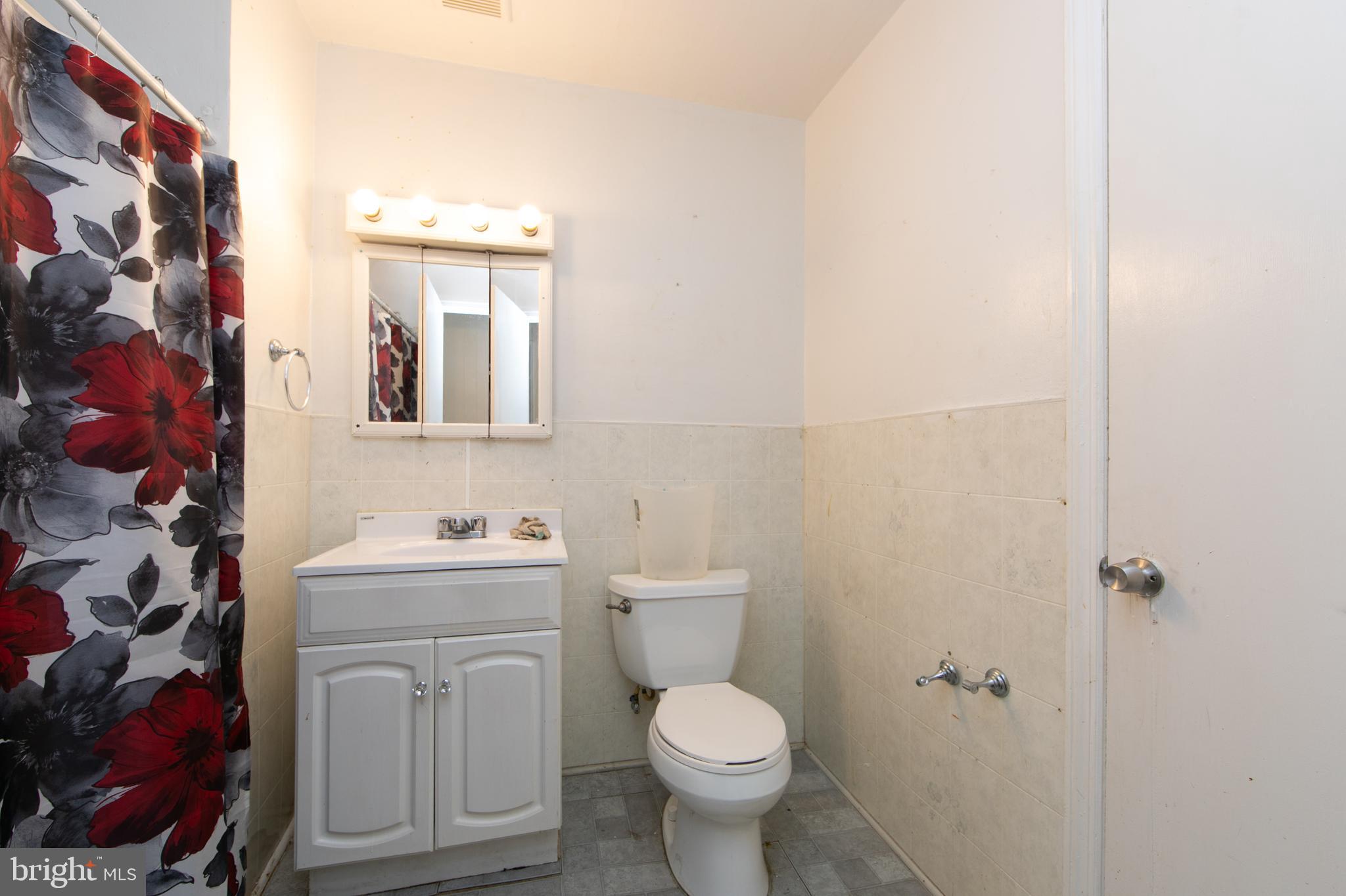 1574 Mt Ephraim Avenue Camden, NJ 08104 - Photo 44 of 54 a bathroom with a toilet a sink and a mirror
