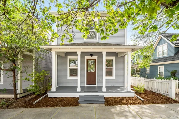 a front view of a house with a tree