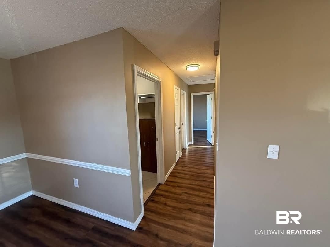 8912 Sherman Road Foley, AL 36535 - Photo 15 of 35 Corridor featuring dark wood-style flooring, a textured ceiling, and baseboards