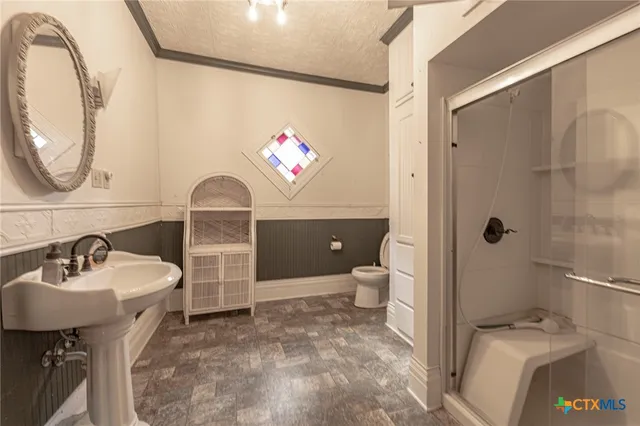 a bathroom with a sink a toilet and a mirror