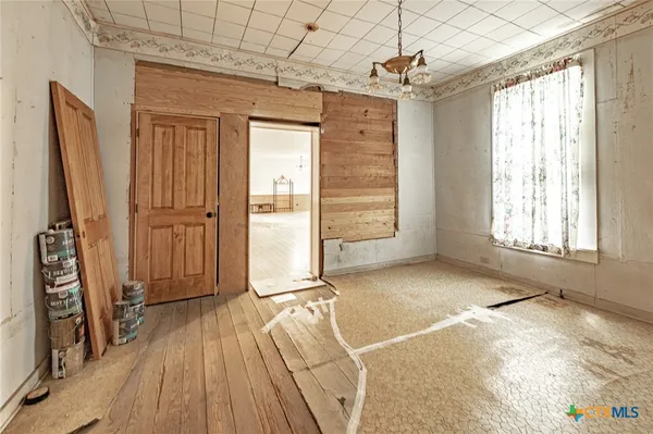 a view of a livingroom with wooden floor and a ceiling fan