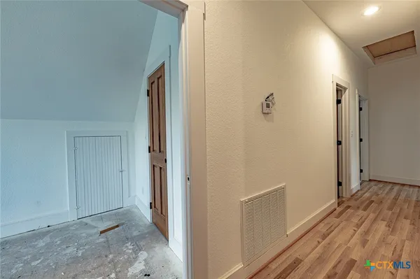 a view of a hallway with wooden floor