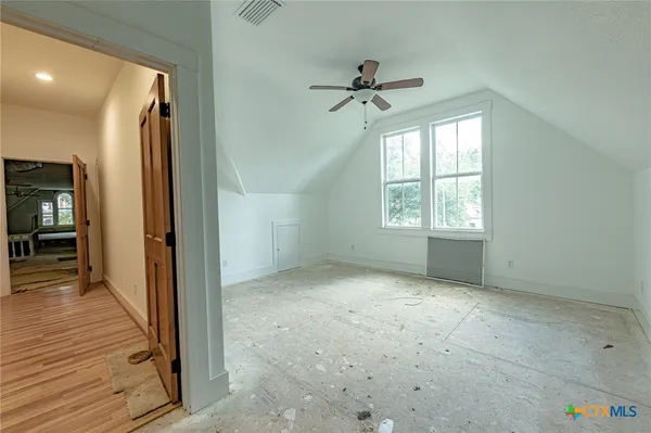 an empty room that has a window and wooden floor