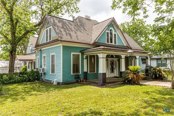 a front view of house with yard outdoor seating and barbeque oven