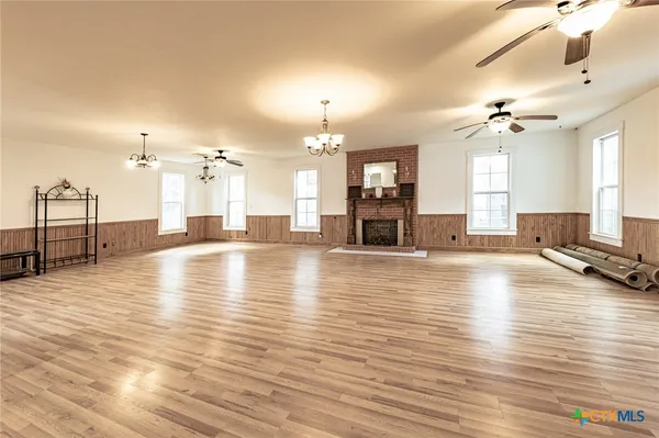 a view of a living room a kitchen with granite countertop a stove and a wooden floor