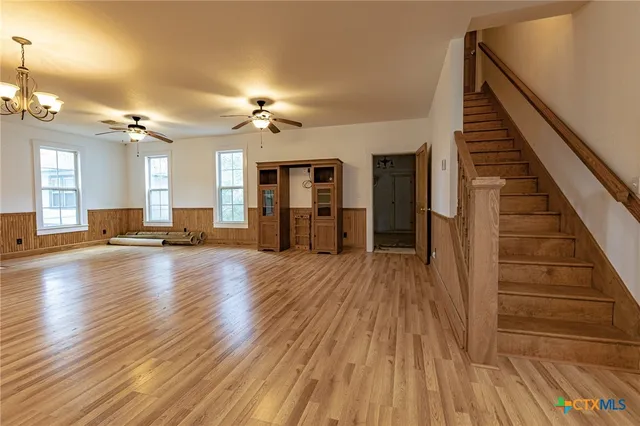an empty room with wooden floor and staircase