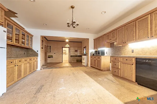 a large kitchen with stainless steel appliances kitchen island granite countertop a stove and cabinets