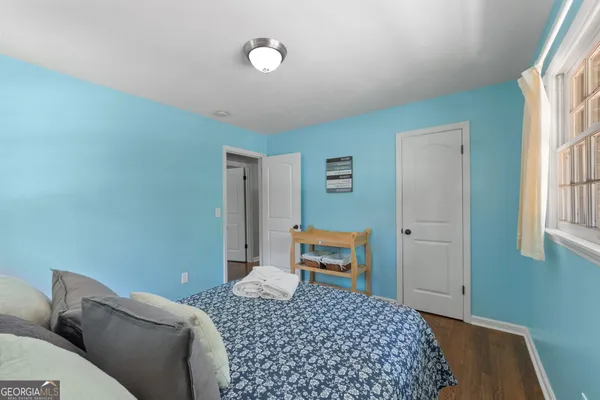 a bedroom with a bed a dresser and a window