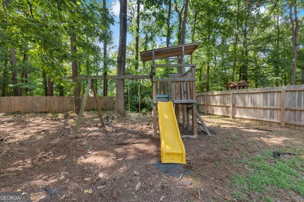 a view of a backyard with a small cabin and wooden fence