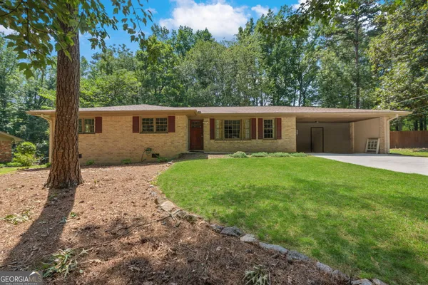 a view of house with backyard and trees