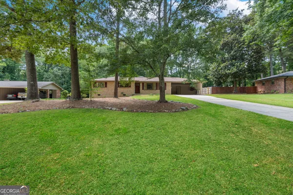 a view of a house with backyard and sitting area