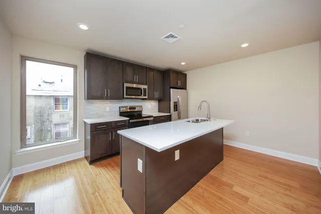 a kitchen with a stove a sink a microwave a counter top space and cabinets