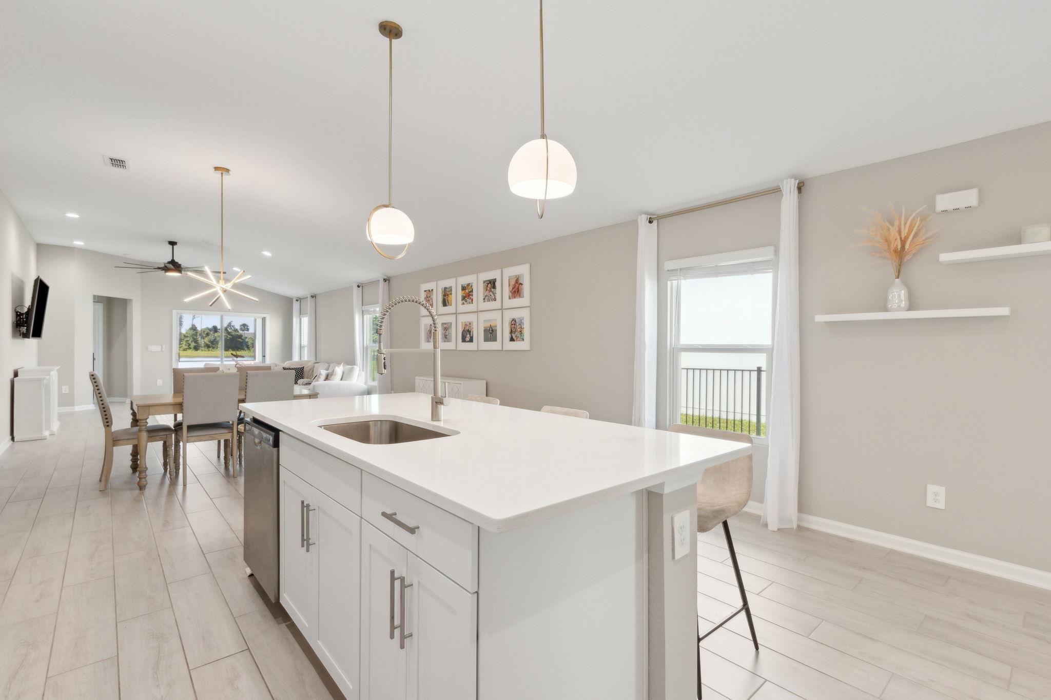 52 Carlota Way St. Augustine, FL 32095 - Photo 3 of 19 a large white kitchen with a large island oven a stove a sink a dining table and chairs
