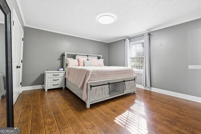 a bedroom with a bed and wooden floor