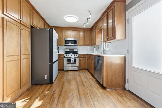 a kitchen with stainless steel appliances wooden cabinets and a stove top oven