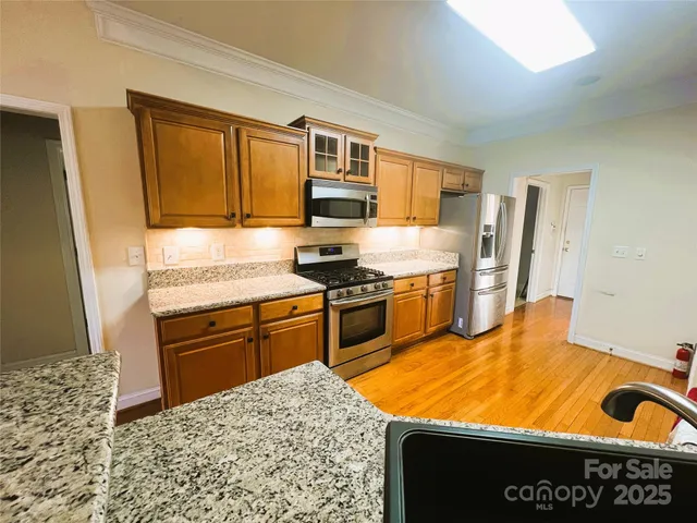 a kitchen with stainless steel appliances granite countertop a sink stove and refrigerator