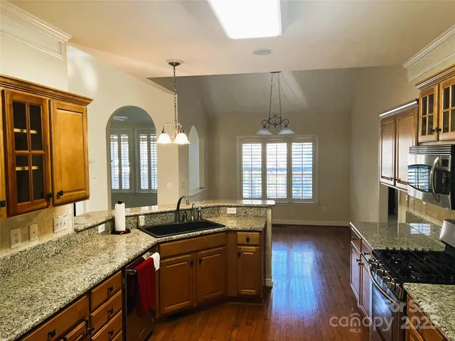 a kitchen with granite countertop a sink and a stove