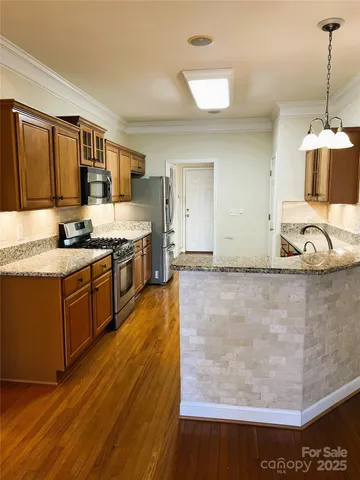 a kitchen with stainless steel appliances granite countertop a stove a sink and a refrigerator