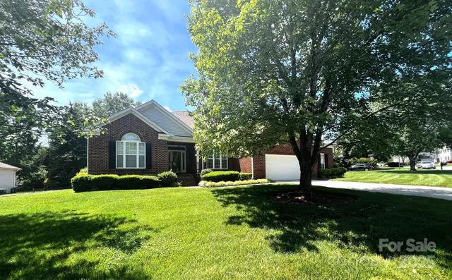 a front view of a house with a yard and trees