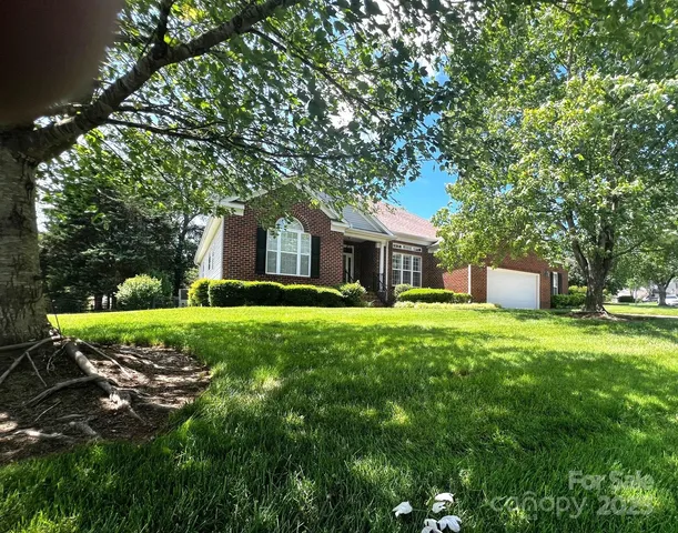 a front view of a house with a yard and trees