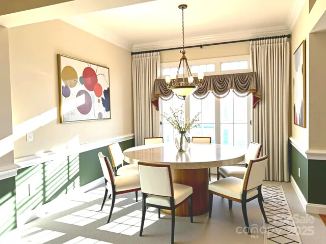 a view of a dining room with furniture a chandelier and a window